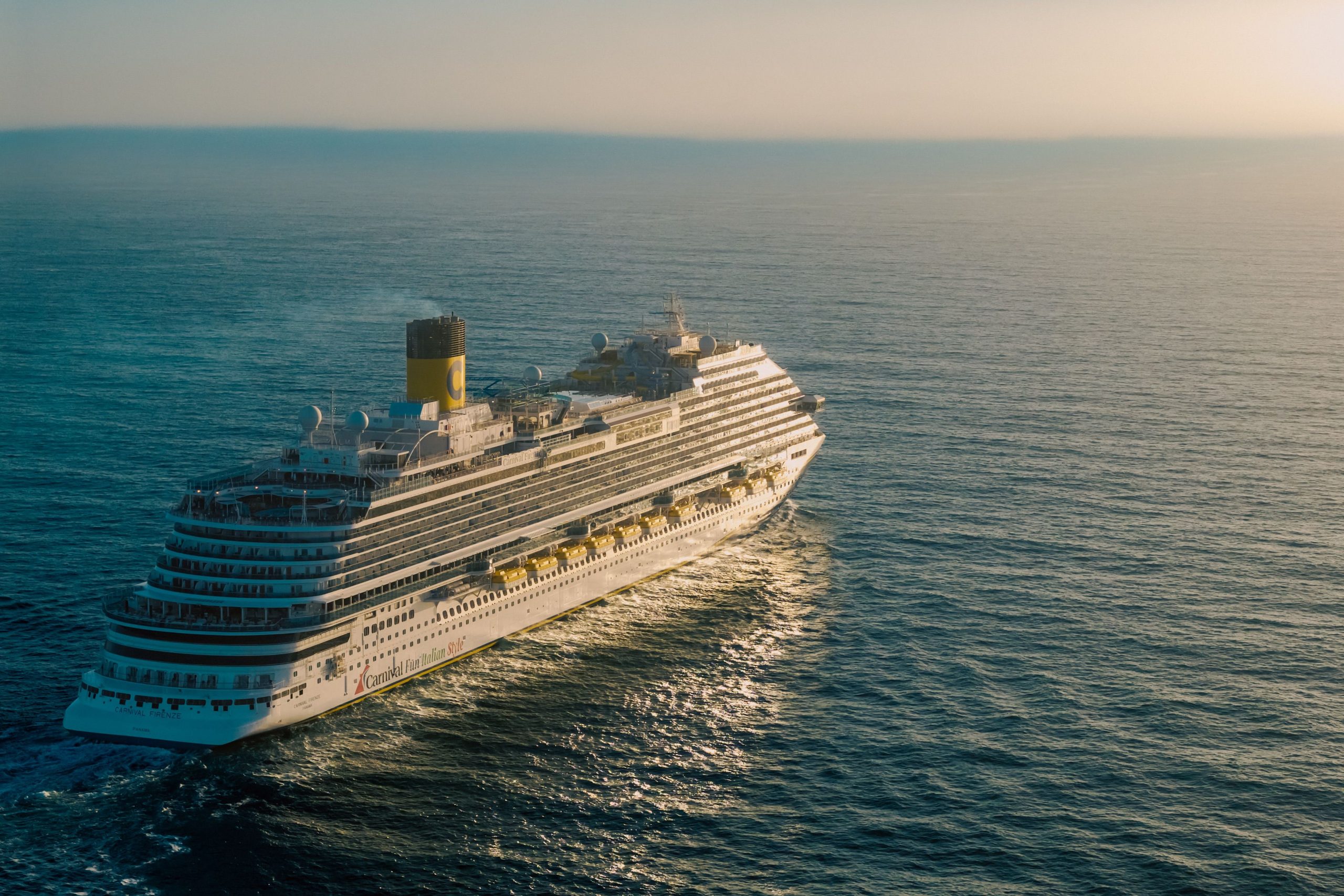 Cruise ship sailing across the ocean at sunset, illustrating fall 2026 cruise destinations