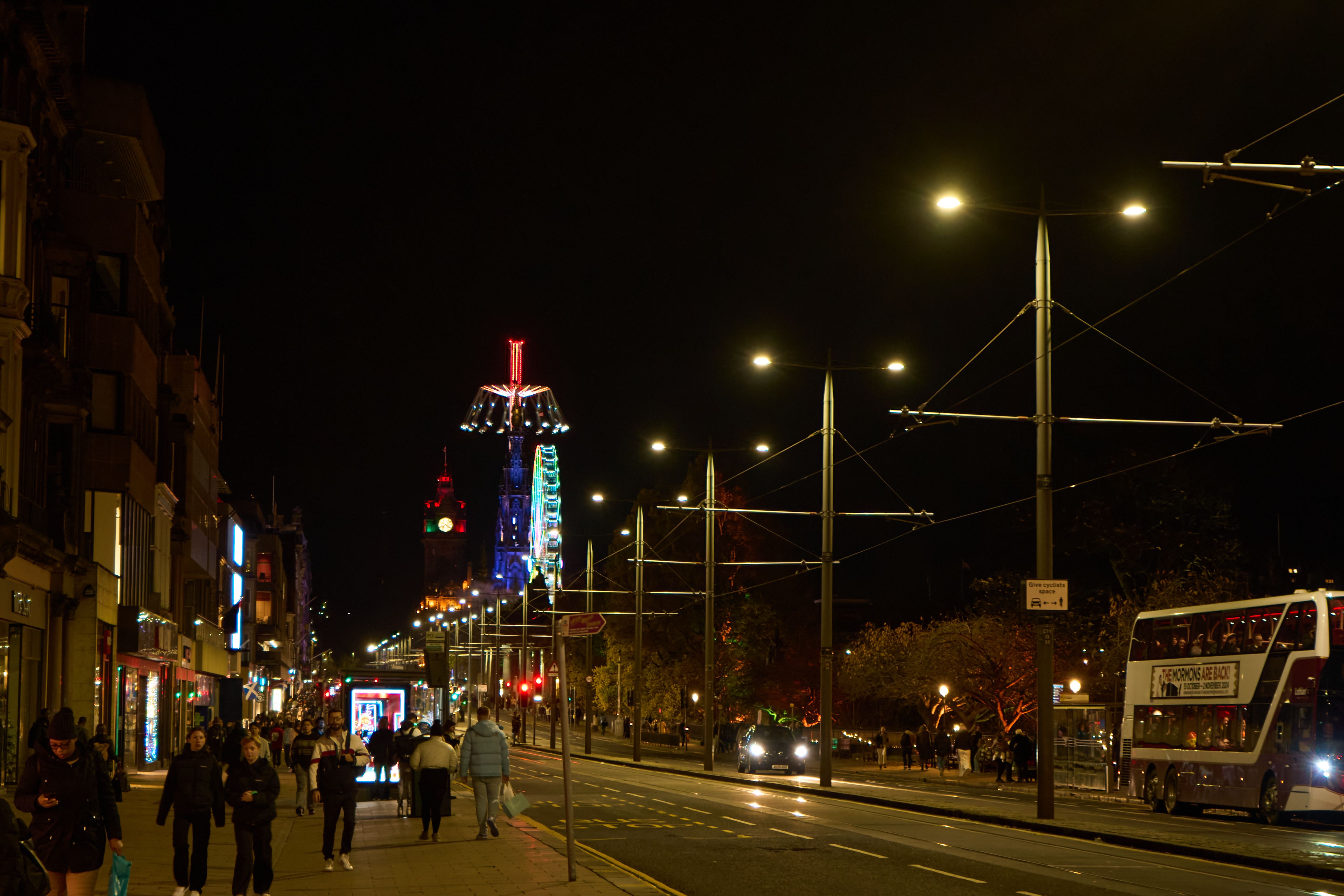 Festive Edinburgh street at night with lights and crowds during Hogmanay