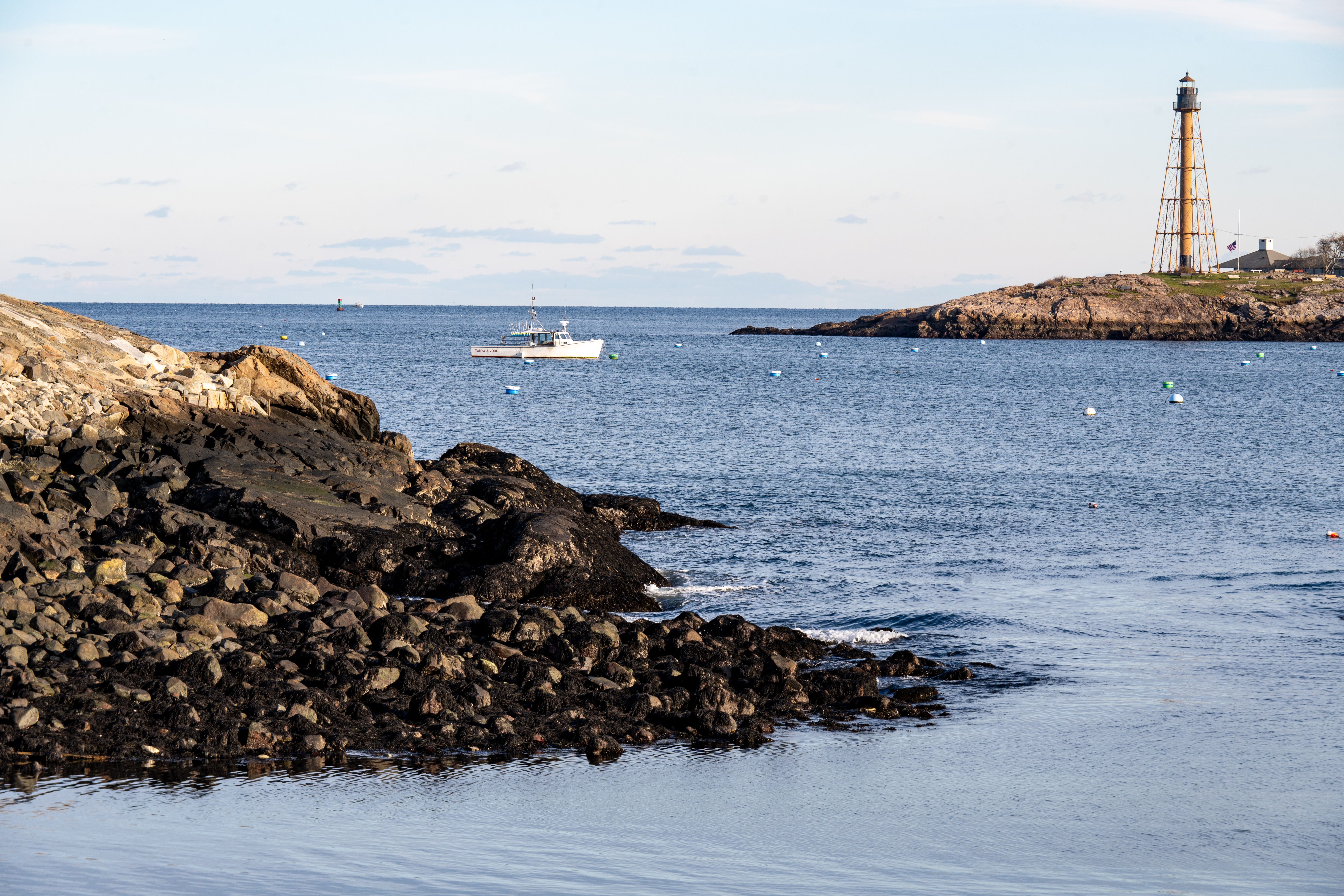 Lighthouse and fishing boat on the New England coast in autumn