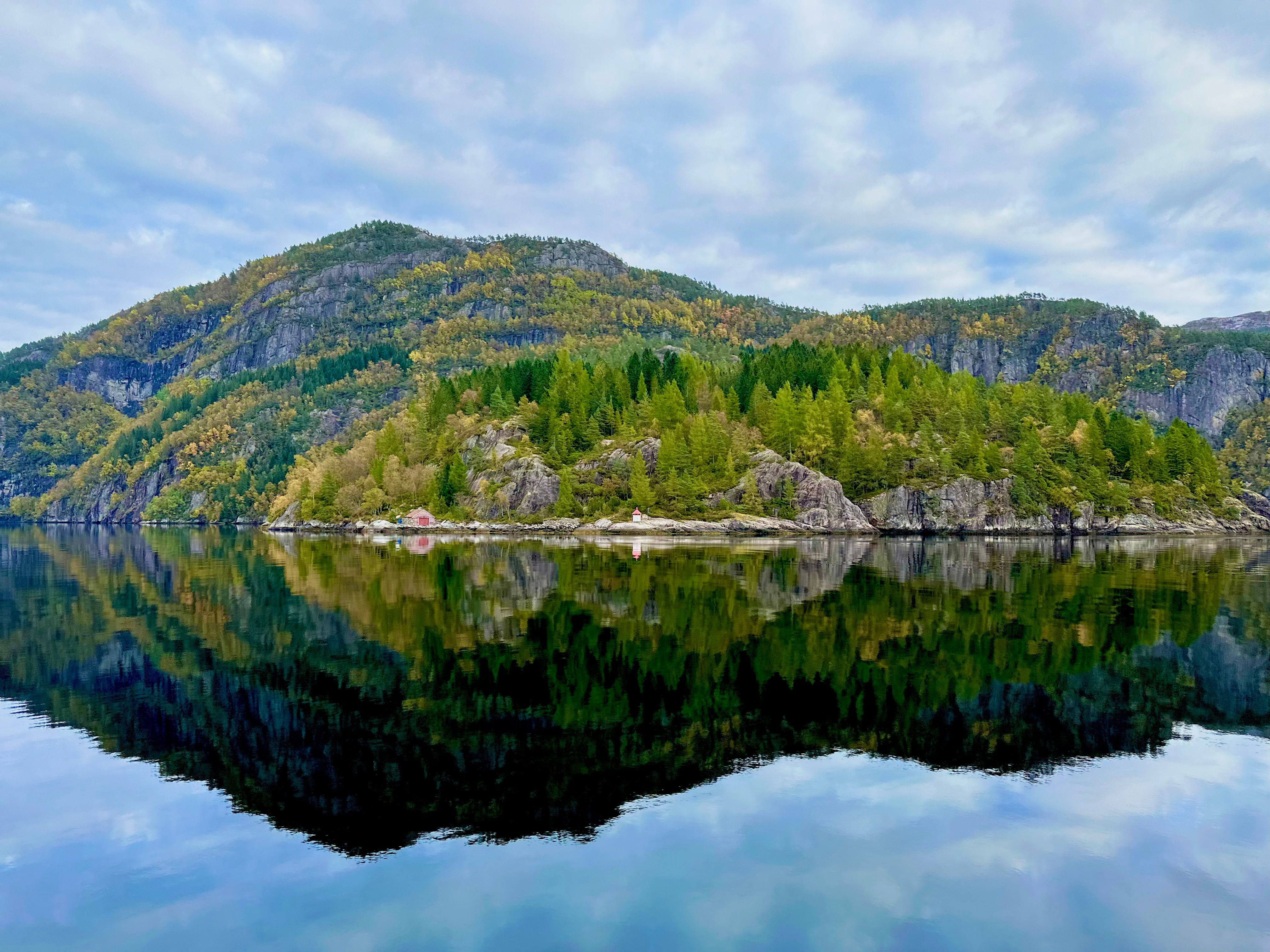 Norwegian fjord landscape reflecting autumn foliage