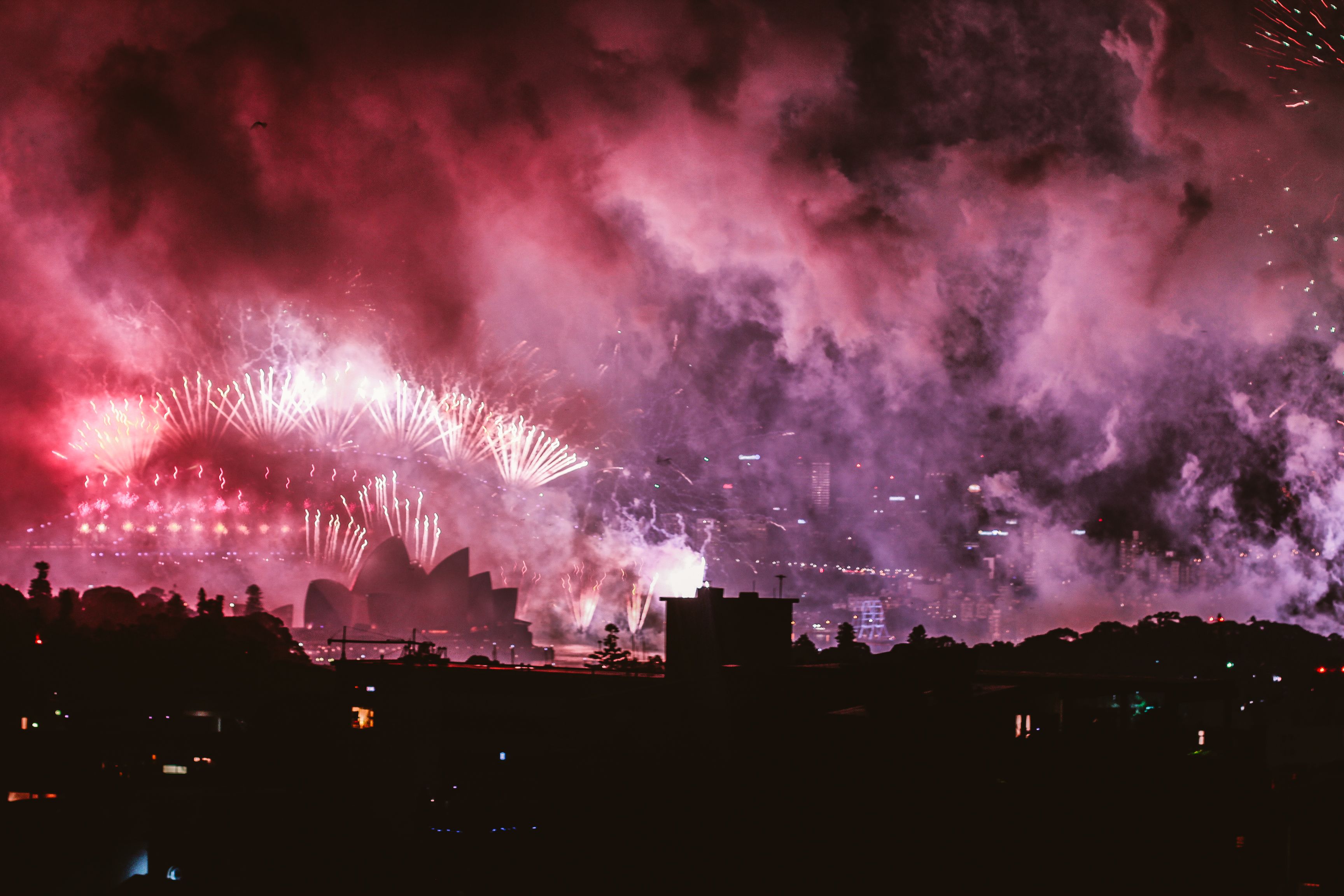 Fireworks bursting over Sydney Opera House and Harbour Bridge on New Year's Eve