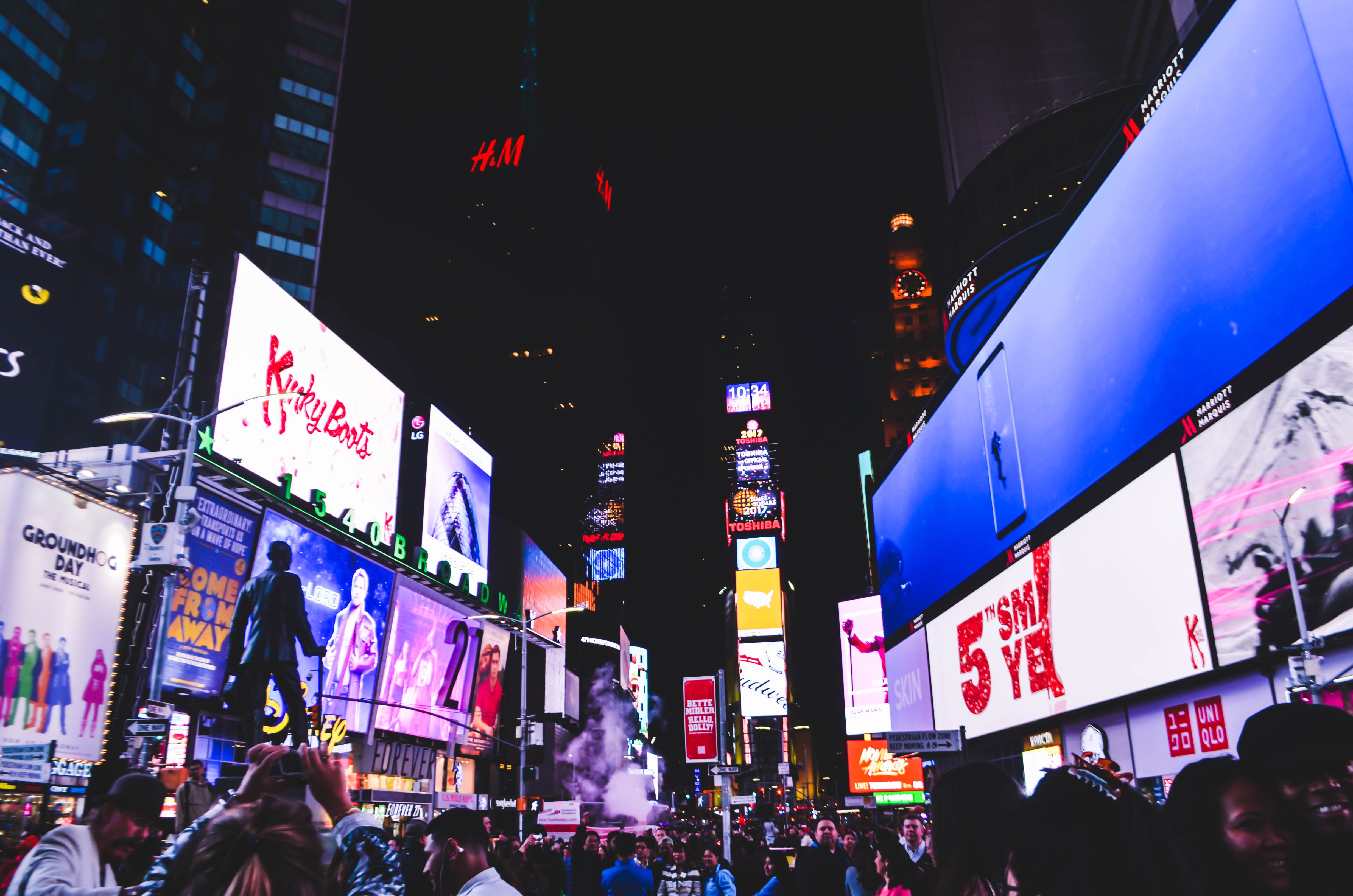 Crowds and bright digital billboards in Times Square, New York City at night